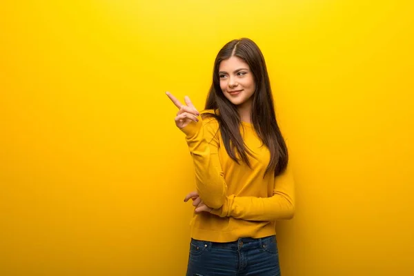 Teenager Mädchen Auf Lebendigem Gelben Hintergrund Zeigt Mit Dem Finger — Stockfoto