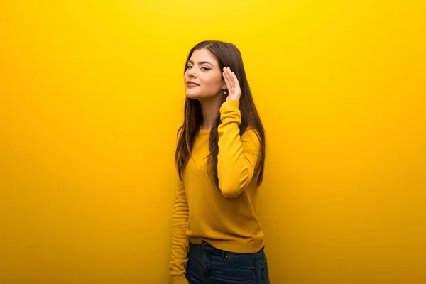 Nastolatek Dziewczyna Żywe Żółtym Tle Słuchając Coś Kładąc Rękę Ucho — Zdjęcie stockowe