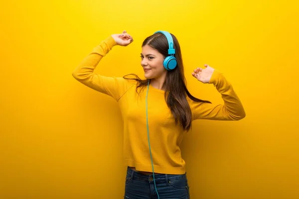 Chica Adolescente Sobre Vibrante Fondo Amarillo Escuchando Música Con Auriculares —  Fotos de Stock