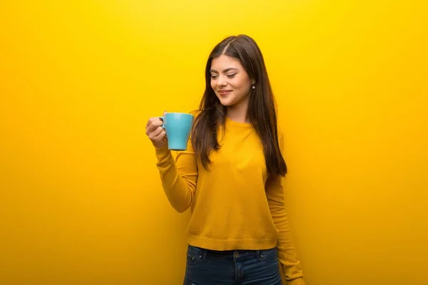 Dospívající Dívka Pulzující Žluté Pozadí Držící Šálek Horké Kávy — Stock fotografie