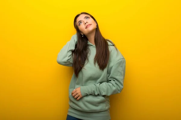 Tinédzser Lány Gondolkodás Egy Ötlet Miközben Fejét Vakarja Sárga Háttéren — Stock Fotó