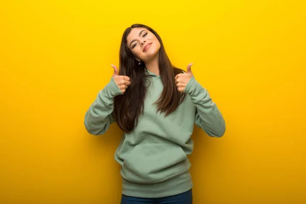 Menina Adolescente Com Camisola Verde Fundo Amarelo Dando Gesto Polegar — Fotografia de Stock