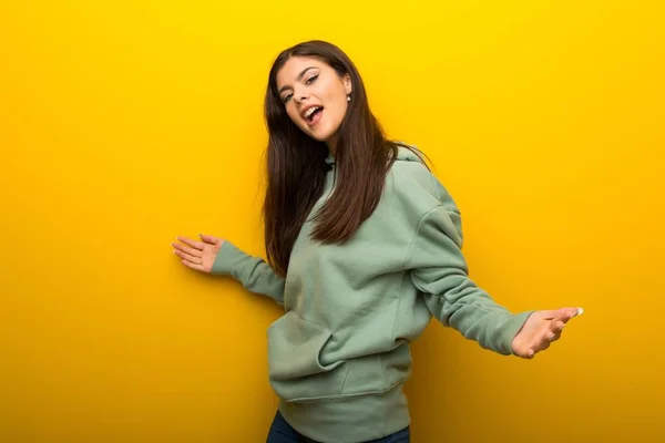 Tiener Meisje Met Groene Sweater Gele Achtergrond Trots Zelfingenomen Hou — Stockfoto