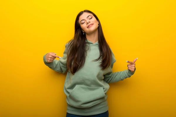 Chica Adolescente Con Sudadera Verde Sobre Fondo Amarillo Orgulloso Auto —  Fotos de Stock