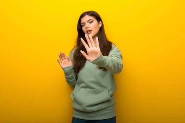 Teenager Mädchen Mit Grünem Sweatshirt Auf Gelbem Hintergrund Ist Etwas — Stockfoto