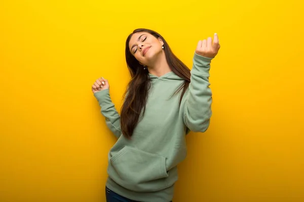 Chica Adolescente Con Sudadera Verde Sobre Fondo Amarillo Disfrutar Bailando —  Fotos de Stock