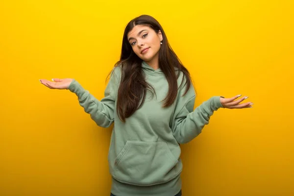 Tiener Meisje Met Groene Sweater Gele Achtergrond Onbelangrijk Gebaar Maken — Stockfoto