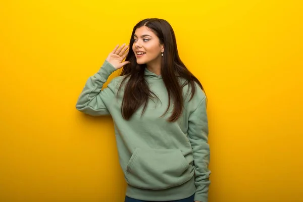 Menina Adolescente Com Camisola Verde Fundo Amarelo Ouvindo Algo Colocando — Fotografia de Stock