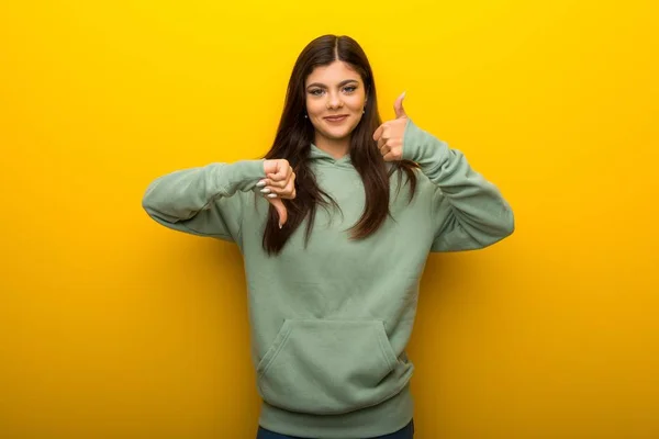 Ragazza Adolescente Con Felpa Verde Sfondo Giallo Facendo Buon Cattivo — Foto Stock