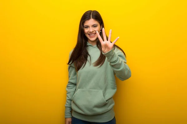 Chica Adolescente Con Sudadera Verde Sobre Fondo Amarillo Feliz Contando —  Fotos de Stock