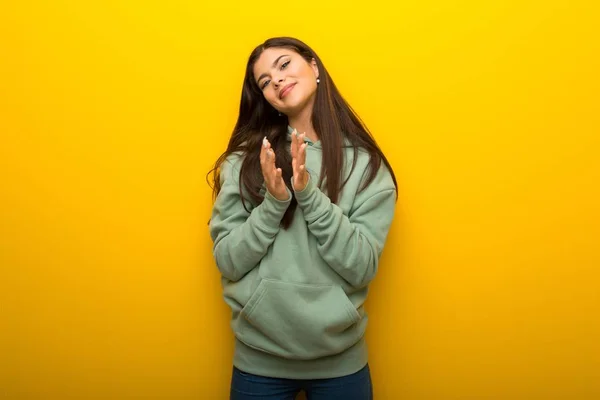 Chica Adolescente Con Sudadera Verde Sobre Fondo Amarillo Aplaudiendo Después —  Fotos de Stock