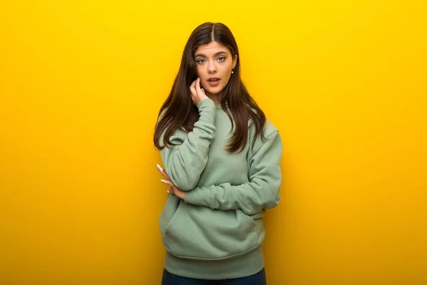 Tiener Meisje Met Groene Sweater Gele Achtergrond Verrast Geschokt Terwijl — Stockfoto