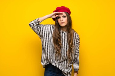 Kızla Fransız tarzı çok uzak bir şey bakmak için el ile seyir sarı duvarın üzerinden