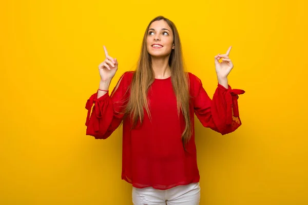 Rapariga Com Vestido Vermelho Sobre Parede Amarela Apontando Com Dedo — Fotografia de Stock