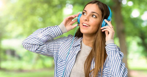 Çizgili Gömlekli Açık Havada Kulaklık Ile Müzik Dinlemek Ile Genç — Stok fotoğraf