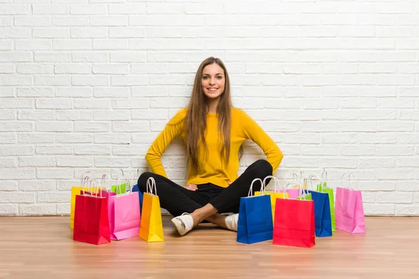 Fiatal Lány Sok Bevásárló Táskák Jelentő Karral Csípő Nevetve Keres — Stock Fotó