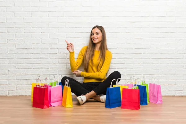 Ung Flicka Med Massa Påsar Pekar Finger Sidan Sidoläge — Stockfoto