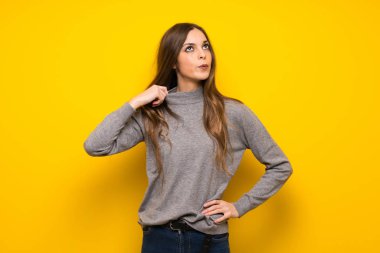 Yorgun ve hasta ifade ile sarı duvarın üzerinden genç kadın