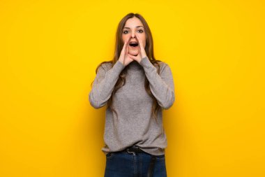 Genç kadın bağırıyor ve bir şey ilan sarı duvarın üzerinden