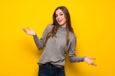 Üzerinde sarı duvar gülümseyen genç kadın