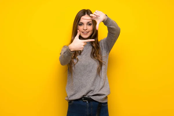 Jovem Mulher Sobre Parede Amarela Focando Rosto Símbolo Enquadramento — Fotografia de Stock