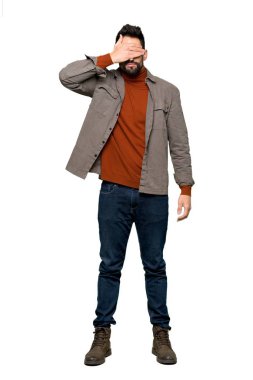 Gözleri eller tarafından kapsayan sakallı yakışıklı adam tam uzunlukta bir kadeh. Bir şey izole beyaz arka plan üzerinde görmek istiyor musunuz