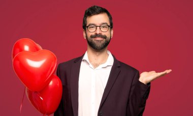 Sevgililer günü holding boşaltmak avuç içinde hayali erkekte kırmızı arka plan üzerinde bir reklam eklemek için