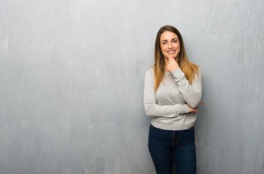 Genç kadın gülümseyerek ve öne doğru emin yüz ile seyir dokulu duvar