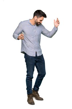 Gömlek telefonda izole beyaz arka plan ile müzik dinleme ile zarif adamın tam uzunlukta atış