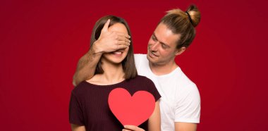 İki kalp simgesi kırmızı arka plan üzerinde tutan Sevgililer günü içinde