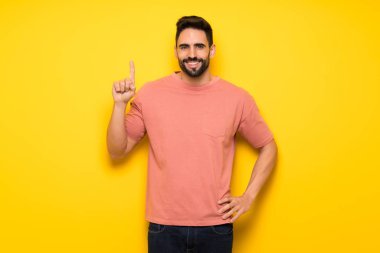 Yakışıklı gösteren ve en iyi iz içinde parmak kaldırma sarı duvarın üzerinden