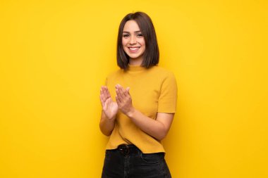 Bir konferansta sunum sonrası sarı duvar alkış üzerinde genç kadın