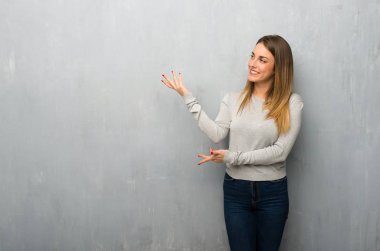 Genç kadın uzanan eller yanına gelmek için davet için dokulu duvar üzerinde