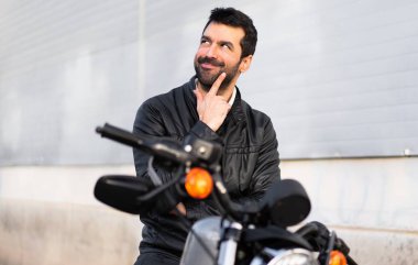 Genç adam bir motosiklet düşünme üzerine