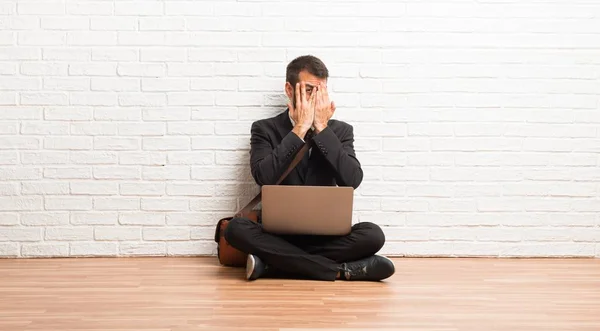 Zakenman Met Zijn Laptop Zittend Vloer Voor Ogen Door Handen — Stockfoto