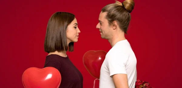 Pareja Día San Valentín Con Flores Sobre Fondo Rojo — Foto de Stock