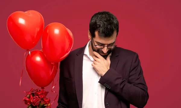 Человек День Святого Валентина Смотрит Вниз Рукой Подбородок Красном Фоне — стоковое фото