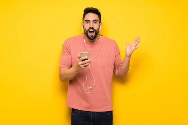 Hombre Guapo Sobre Pared Amarilla Sorprendido Enviando Mensaje —  Fotos de Stock