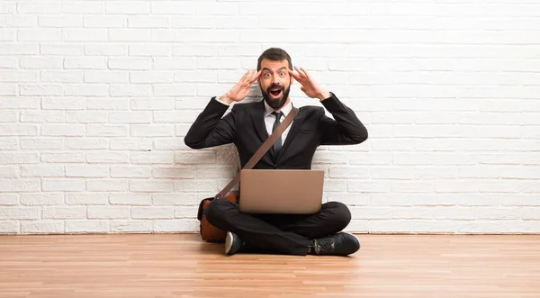 Zakenman Met Zijn Laptop Zittend Vloer Verrast Geschokt Gelaatsuitdrukking — Stockfoto