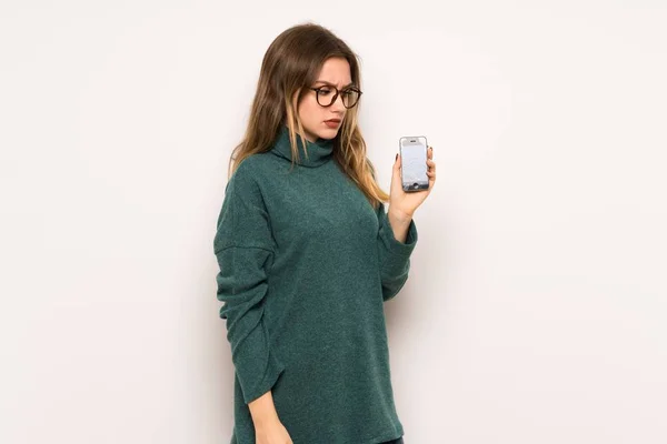 Dospívající Dívka Nad Bílé Zdi Trápí Držení Přerušeno Smartphone — Stock fotografie