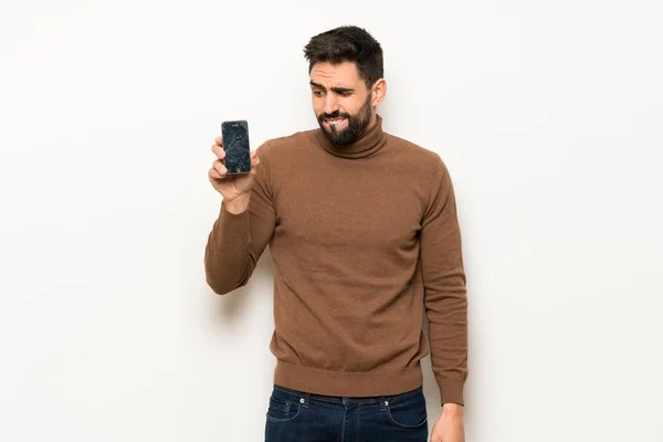 Bonito Homem Sobre Parede Branca Com Conturbado Segurando Smartphone Quebrado — Fotografia de Stock