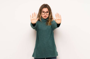 Genç kız dur jest yapmak için beyaz duvar üzerinde bir görüş ile hayal kırıklığına