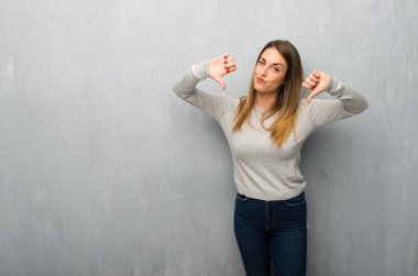 Dokulu duvar başparmak aşağı her iki el ile gösterilen genç kadın