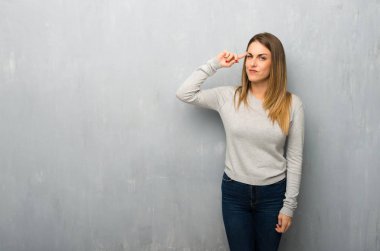 Genç kadın dokulu duvar parmak kafasına koyarak delilik jest yapma