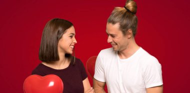 Sevgililer günü çok kırmızı arka plan üzerinde gülümseyen içinde çift