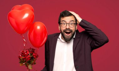 Erkekte parmak tarafına işaret ve kırmızı arka plan üzerinde bir ürün sunma Sevgililer günü