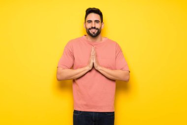 Yakışıklı adam sarı duvarın üzerinden birlikte palm tutar. Kişi için bir şey sorar