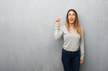 Parmak kaldırma sırasında çözüm dokulu duvar niyetinde üzerinde genç kadın anlar