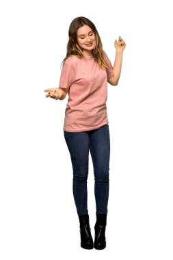 İzole beyaz zemin üzerinde bir reklam eklemek için bir genç kızla pembe kazak boşaltmak hayali avuç içinde tutarak tam uzunlukta bir kadeh