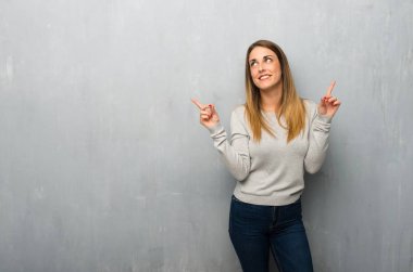 Harika bir fikir işaret parmağı ile işaret dokulu duvar genç kadın